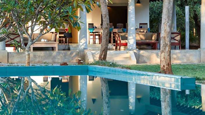 Ein Haus mit einem Pool und einer Veranda dahinter