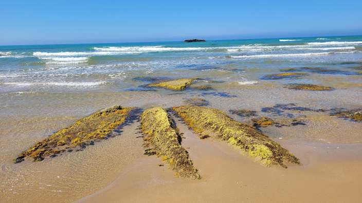 Strand im Süden von Sizilien  Ein Strand mit einem großen Felsen im Vordergrund