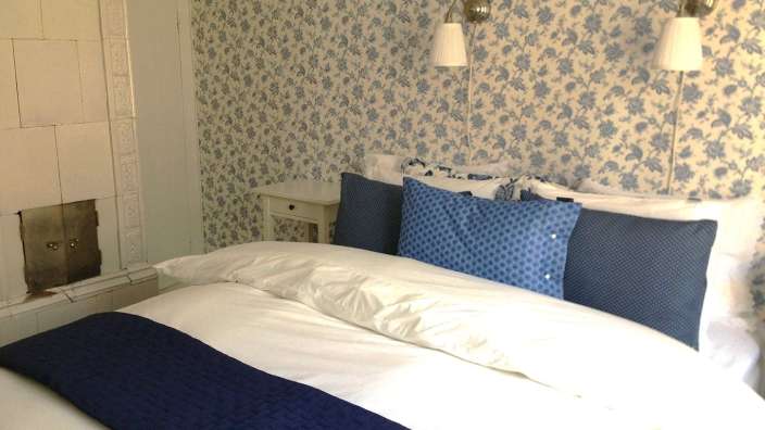 Ein Bett mit weißem Bettbezug und blauen Kissen