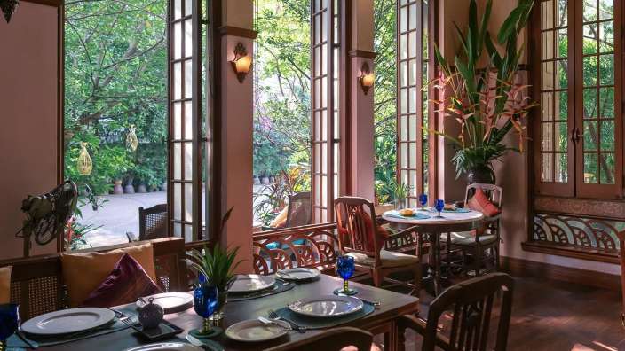 Ein Esszimmer mit Tischen und Stühlen und vielen Fenstern