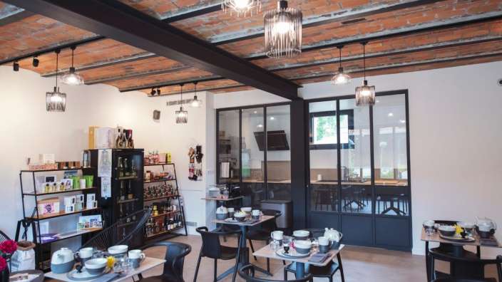 Ein Esszimmer mit Tischen und Stühlen und einem Regal mit Produkten