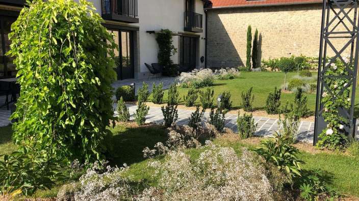Ein Garten mit einem weißen Haus im Hintergrund