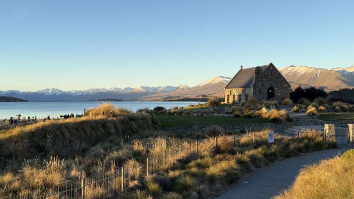 Eine kleine Kirche steht auf einem Hügel mit Blick auf einen See