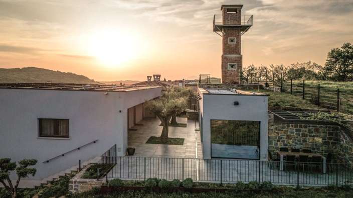 Ein weißes Haus mit einem Backsteinturm dahinter