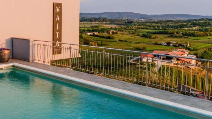 Ein swimmingpool neben einem gebäude mit dem schriftzug vajata
