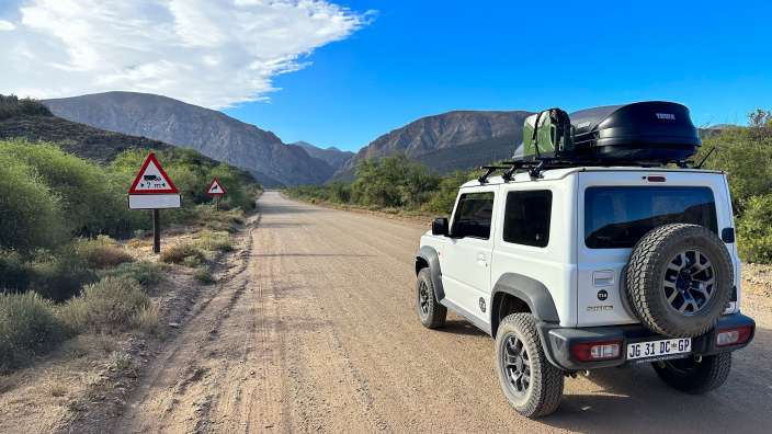 Ein weißer jeep fährt auf einer unbefestigten straße