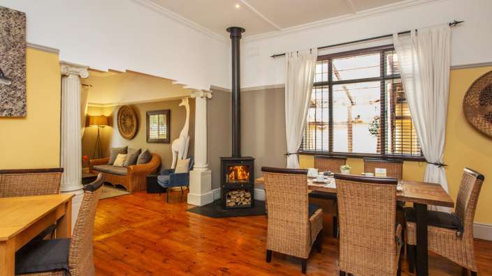 Ein Esszimmer mit Tisch und Stühlen und einem Holzofen