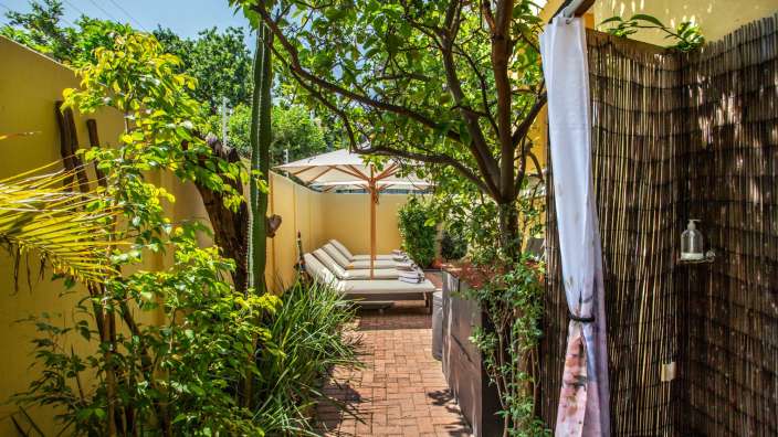 Eine Terrasse mit Liegestühlen und einem Sonnenschirm