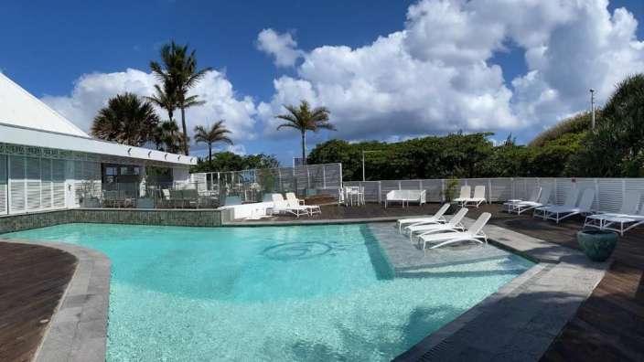 Ein großer Swimmingpool mit weißen Stühlen umgeben
