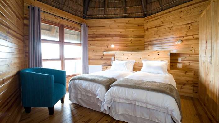 Ein Schlafzimmer mit zwei Betten und einem blauen Stuhl