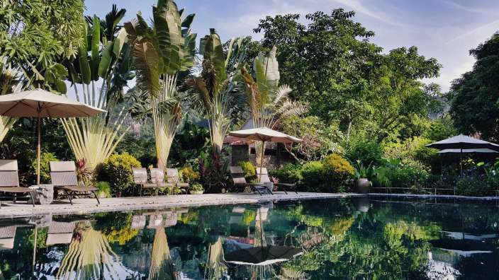 Liegestühle und Sonnenschirme umgeben einen großen Swimmingpool