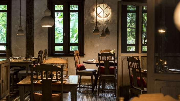 Ein Esszimmer mit Tisch und Stühlen und vielen Fenstern