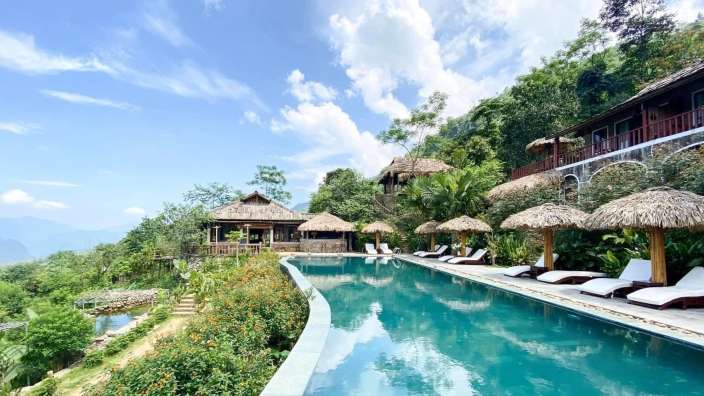 Ein großer Swimmingpool umgeben von Stühlen und Schirmen