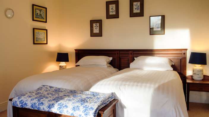 Ein Schlafzimmer mit zwei Betten und drei Bildern an der Wand