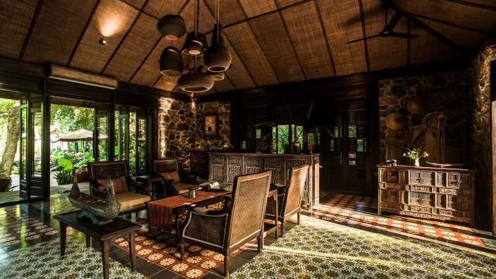 Ein Wohnzimmer mit einem Tisch und Stühlen und einem Deckenventilator