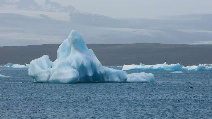 Ein großer blauer Eisberg schwimmt im Ozean