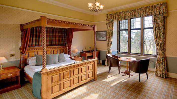 Ein Schlafzimmer mit einem Himmelbett und einem Tisch