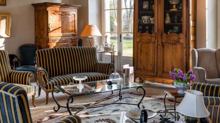 Ein Wohnzimmer mit gestreiften Möbeln und einem Glastisch