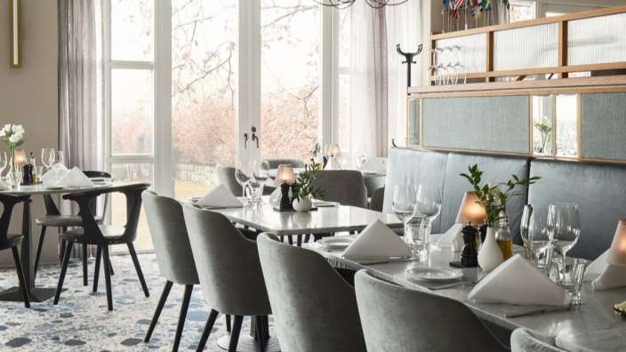 Ein Esszimmer mit vielen Tischen und Stühlen