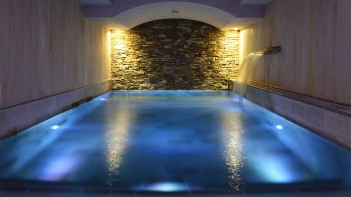 Ein Schwimmbad mit blauem Wasser und einem Wasserfall