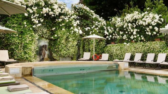 Ein großer Pool mit Liegestühlen und Sonnenschirmen umgeben