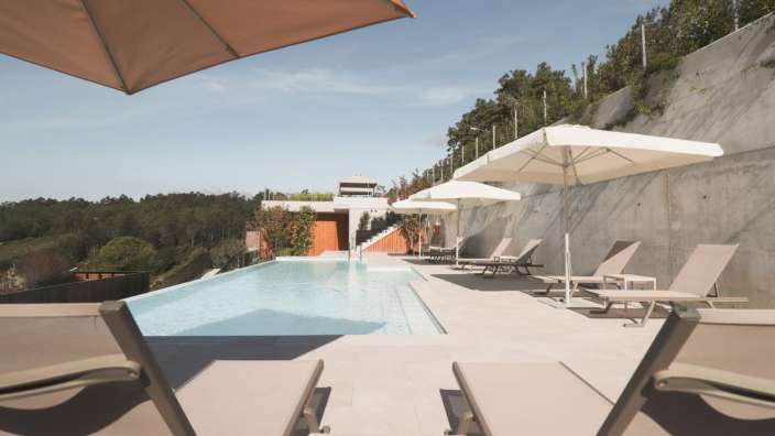 Liegestühle und Sonnenschirme umgeben einen großen Pool