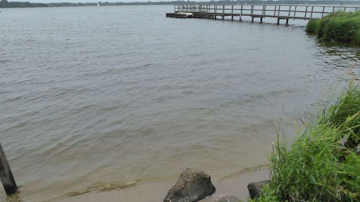 Ein See mit einem Holzsteg in der Ferne