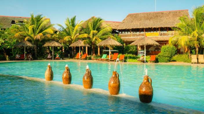 Ein großer Swimmingpool mit Wasserfontänen im Vordergrund
