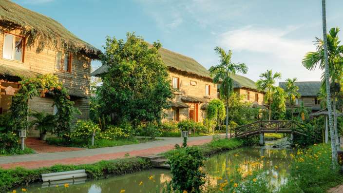 Eine Brücke über einen kleinen Fluss führt zu einem Reihenhaus