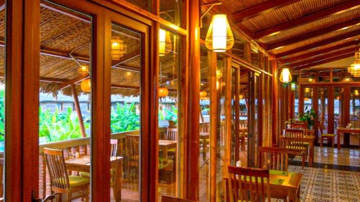 Ein Restaurant mit Tisch und Stühlen und vielen Fenstern