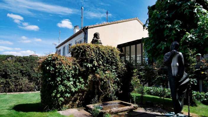 Eine Statue steht in einem Garten neben einem Brunnen