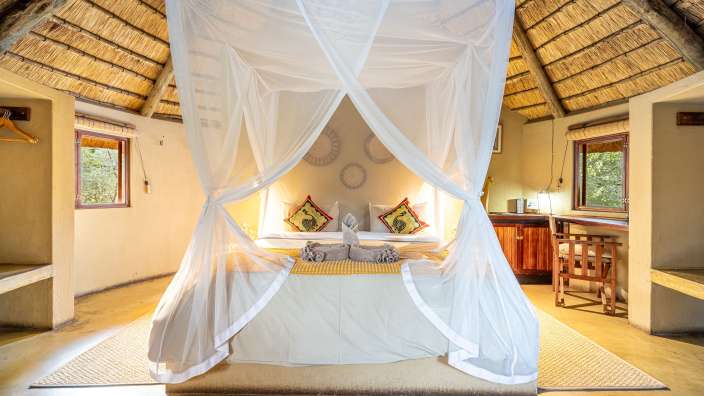 Ein Schlafzimmer mit einem Bett und einem Mosquitonetz