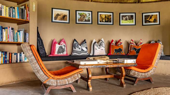 Ein Wohnzimmer mit Stühlen und einem Tisch mit Kissen darauf