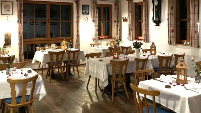 Ein Restaurant mit vielen Tischen und Stühlen und einer Uhr an der Wand