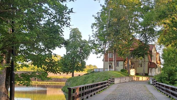 Eine Brücke über einen Fluss mit einem Gebäude im Hintergrund
