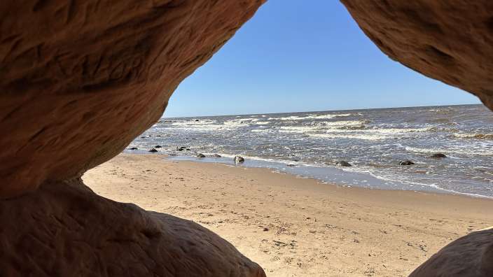 Ein Blick auf den Strand aus einer Höhle