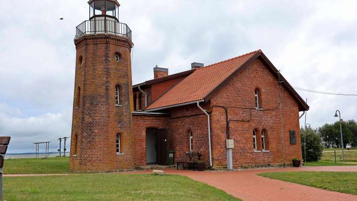 Ein rotes Backsteingebäude mit einem weißen Turm darauf