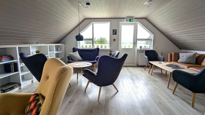 Ein Wohnzimmer mit vielen Stühlen und einem Tisch