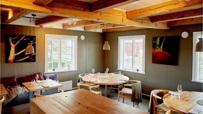 Ein Esszimmer mit Holzböden und einem Bild einer Tomate an der Wand