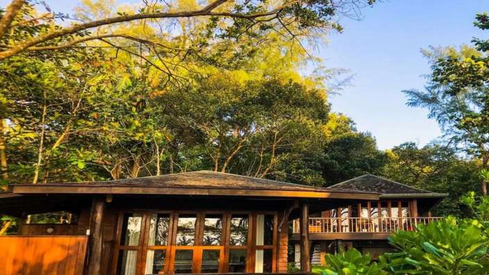 Ein kleines Holzhaus im Wald mit vielen Fenstern