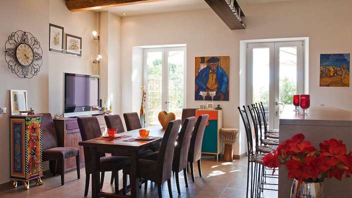 Ein Esszimmer mit einem Tisch und Stühlen und einer Uhr an der Wand