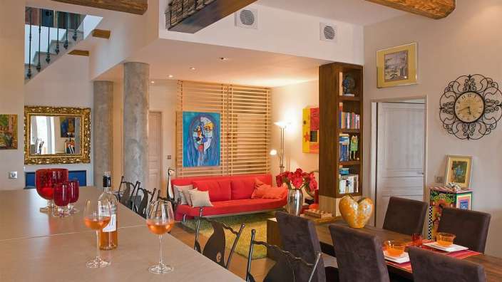 Ein Wohnzimmer mit einem roten Couch und einer Uhr an der Wand