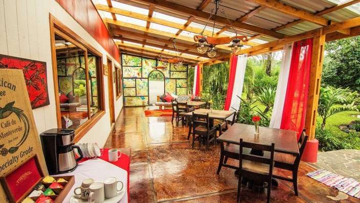 Ein Tisch mit Tassen und einer Kaffeemaschine neben einem Zeichen, das sagt " cafe de monteverde "