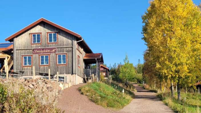 Ein braunes Holzhaus mit einem Schild an der Seite, das sagt ' fredsgården '