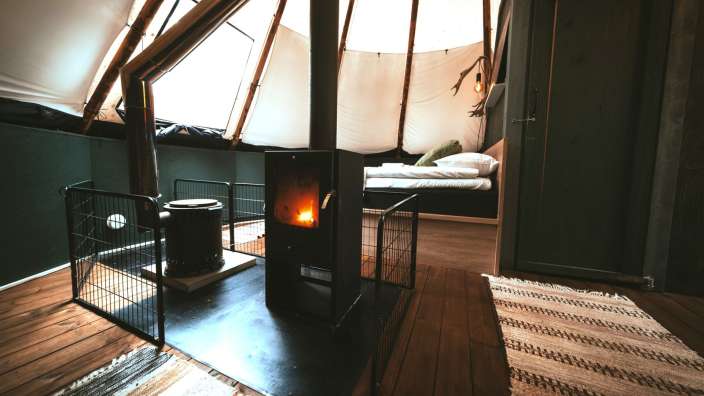 Ein Kamin in einem Raum neben einem Bett