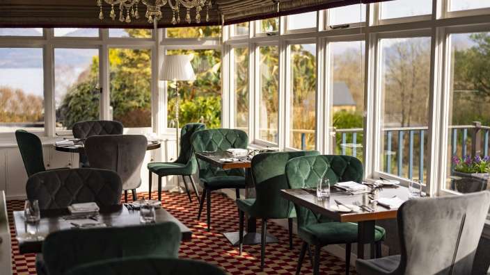 Ein Esszimmer mit Tisch und Stühlen und vielen Fenstern