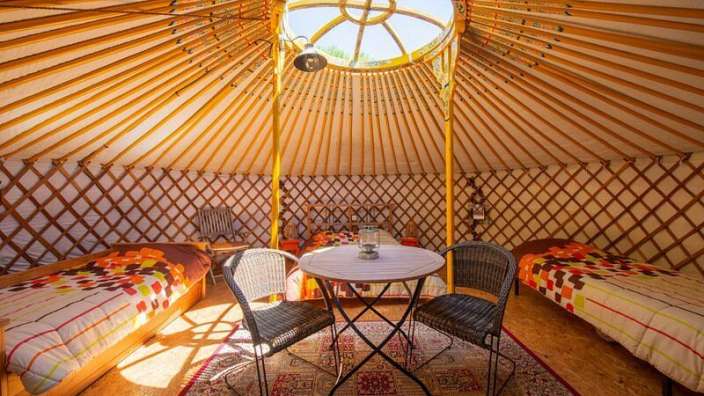 Ein yurt mit zwei Betten und einem Tisch