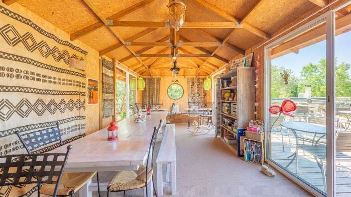 Ein Raum mit einem Tisch und Stühlen und einem Bücherregal