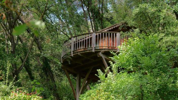 Ein Baumhaus mit einem Balkon im Wald