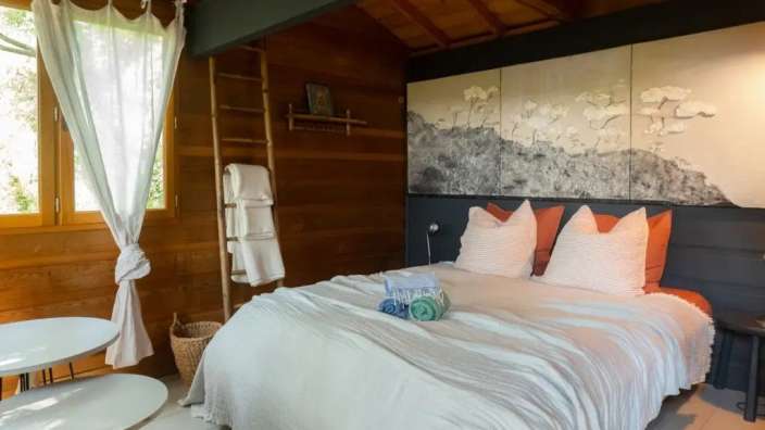 Ein Schlafzimmer mit einem Bett und einem Gemälde an der Wand